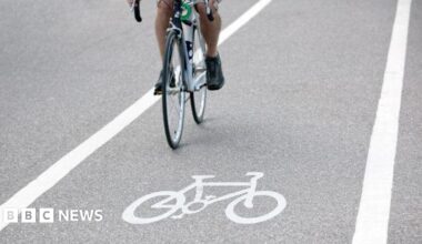 A stock image of a person riding a bicycle over a bike path symbol.