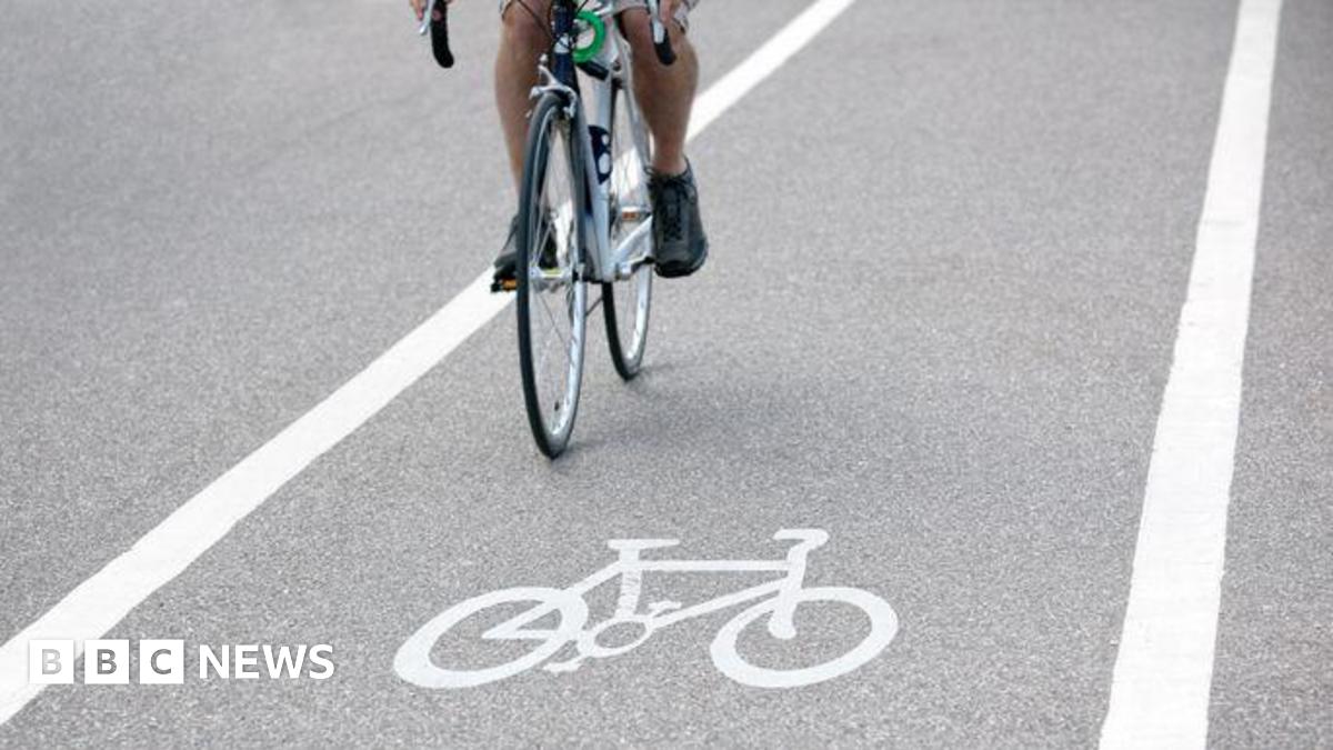 A stock image of a person riding a bicycle over a bike path symbol.
