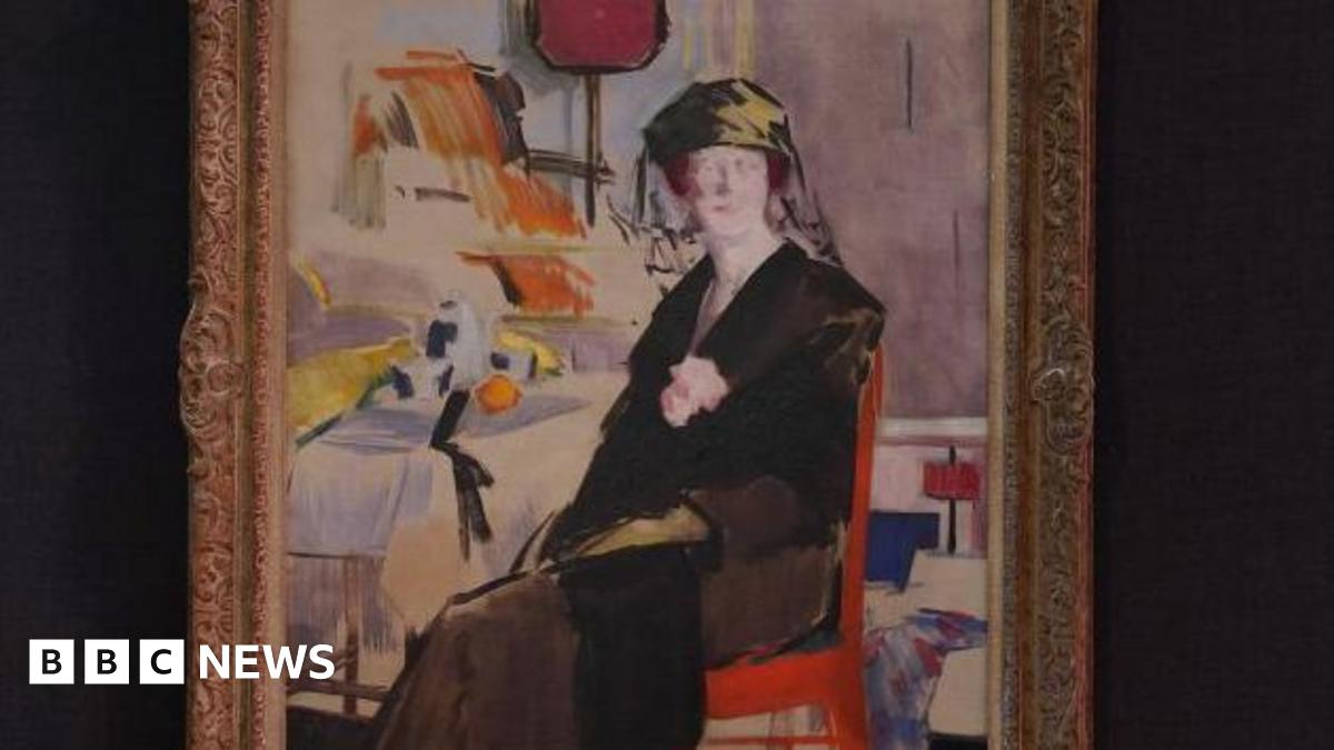 An oil painting of a woman wearing black sitting on a chair. There are other pieces of furniture in the background. The painting is framed and hung on a black wall.
