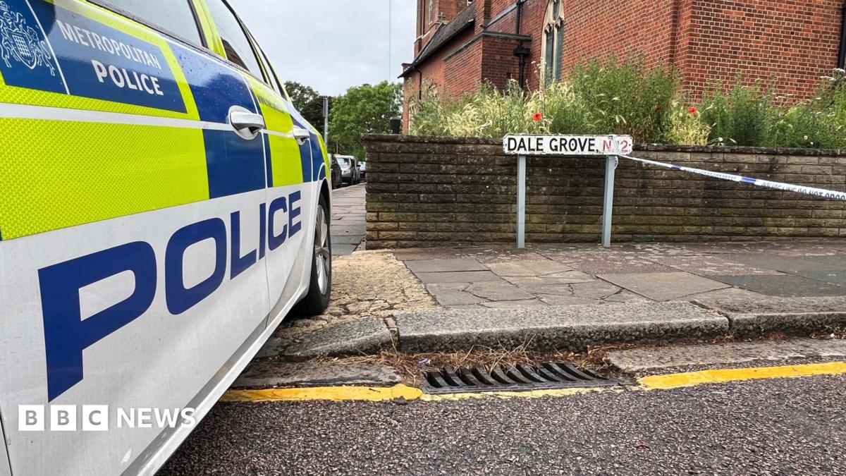 Metropolitan Police car parked beside a street sign reading "Dale Grove N12", with police cordon tape strung across the road and a red-brick church behind.