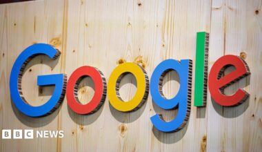 The Google logo (which is the word 'Google' with 'G' in blue, 'o' in red, 'o' in yellow, 'g' in blue, 'l' in green, and 'e' in red) on a wooden wall. The letters are made of cardboard.