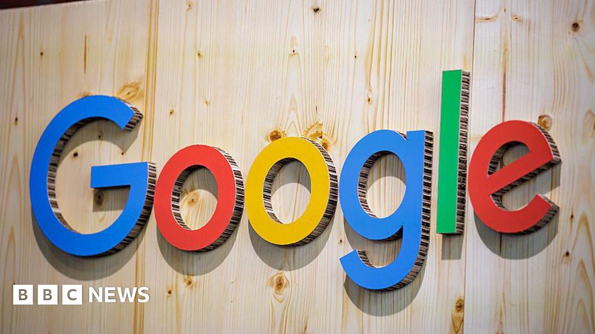 The Google logo (which is the word 'Google' with 'G' in blue, 'o' in red, 'o' in yellow, 'g' in blue, 'l' in green, and 'e' in red) on a wooden wall. The letters are made of cardboard.