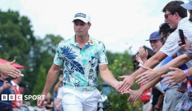 Viktor Hovland of Norway high fives fans while walking towards the first tee box during the final round of the 2026 Travelers Championship