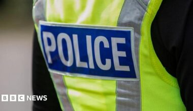 Police officer wearing a high vis jacket that says "police"