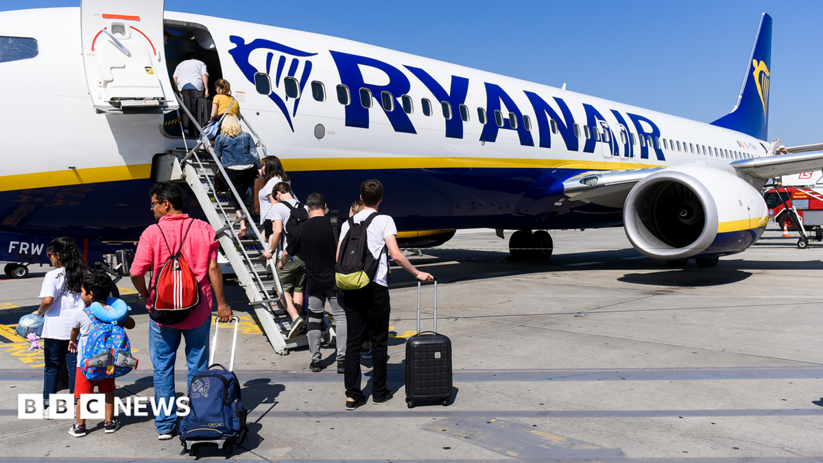 Passengers incluidng children boarding a Ryanair aircraft using the steps at the front of the plane on a sunny day with blue skies