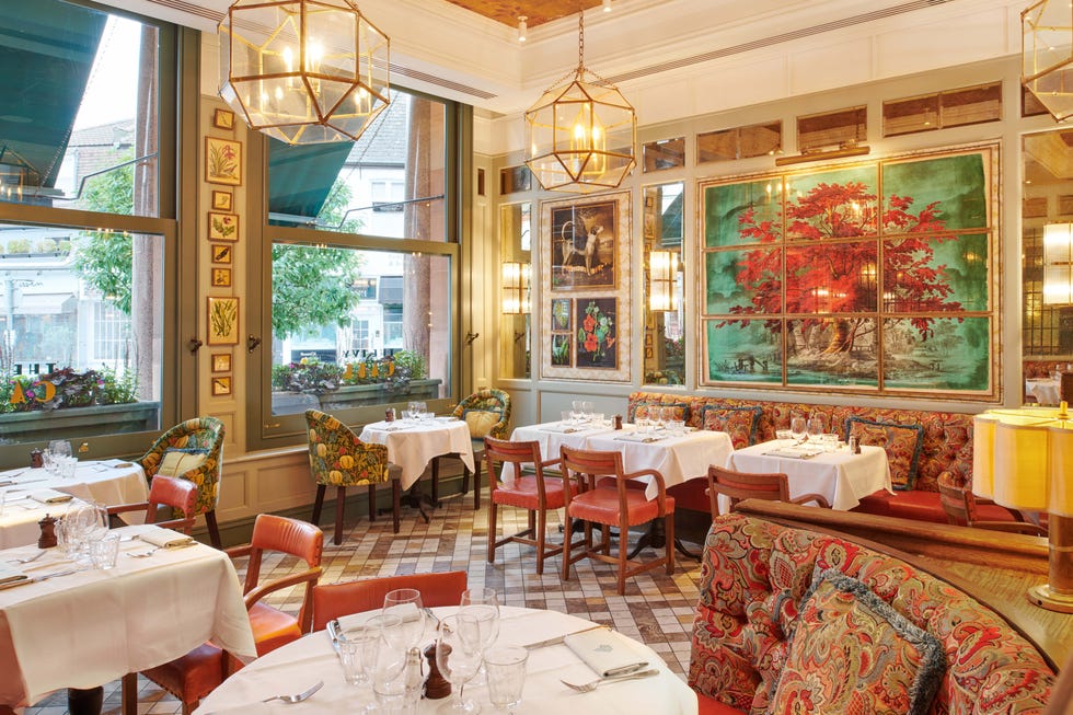 Elegant restaurant interior with colorful decor and white tablecloths.