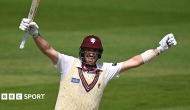 Craig Overton, with arms outstretched and bat raised, celebrates reaching a century for Somerset
