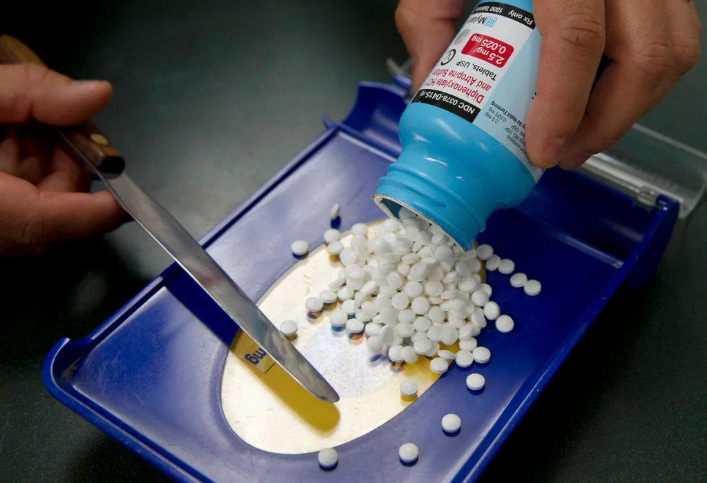 Pills empties onto a tray from a bottle