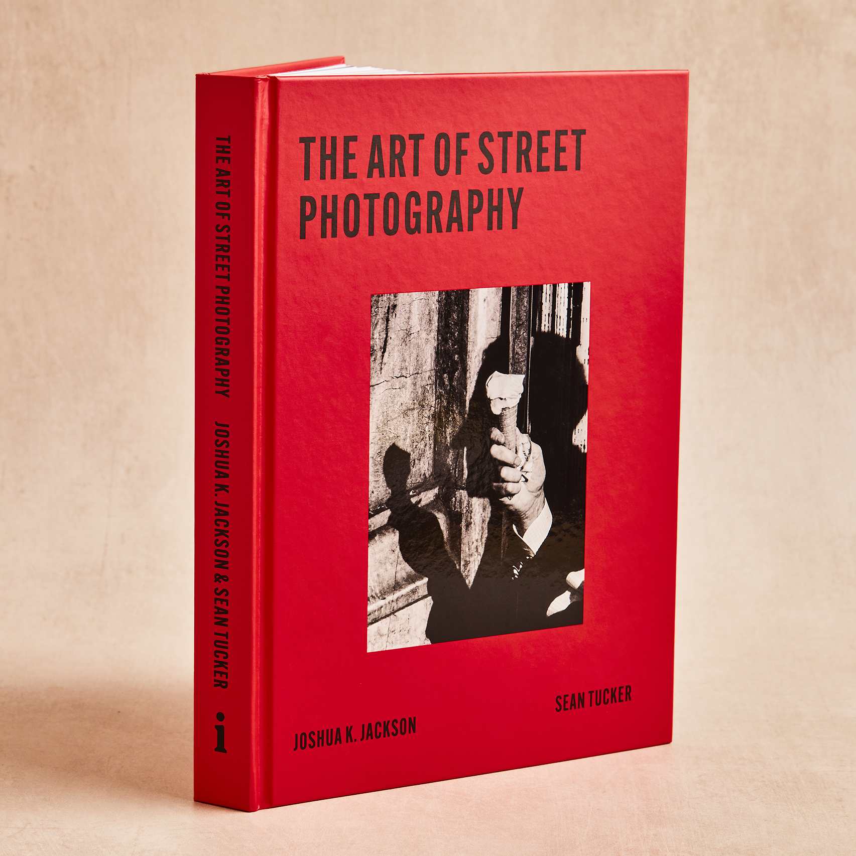 A three-quarter view of the red hardback edition of The Art of Street Photography, showing both the front cover and spine.