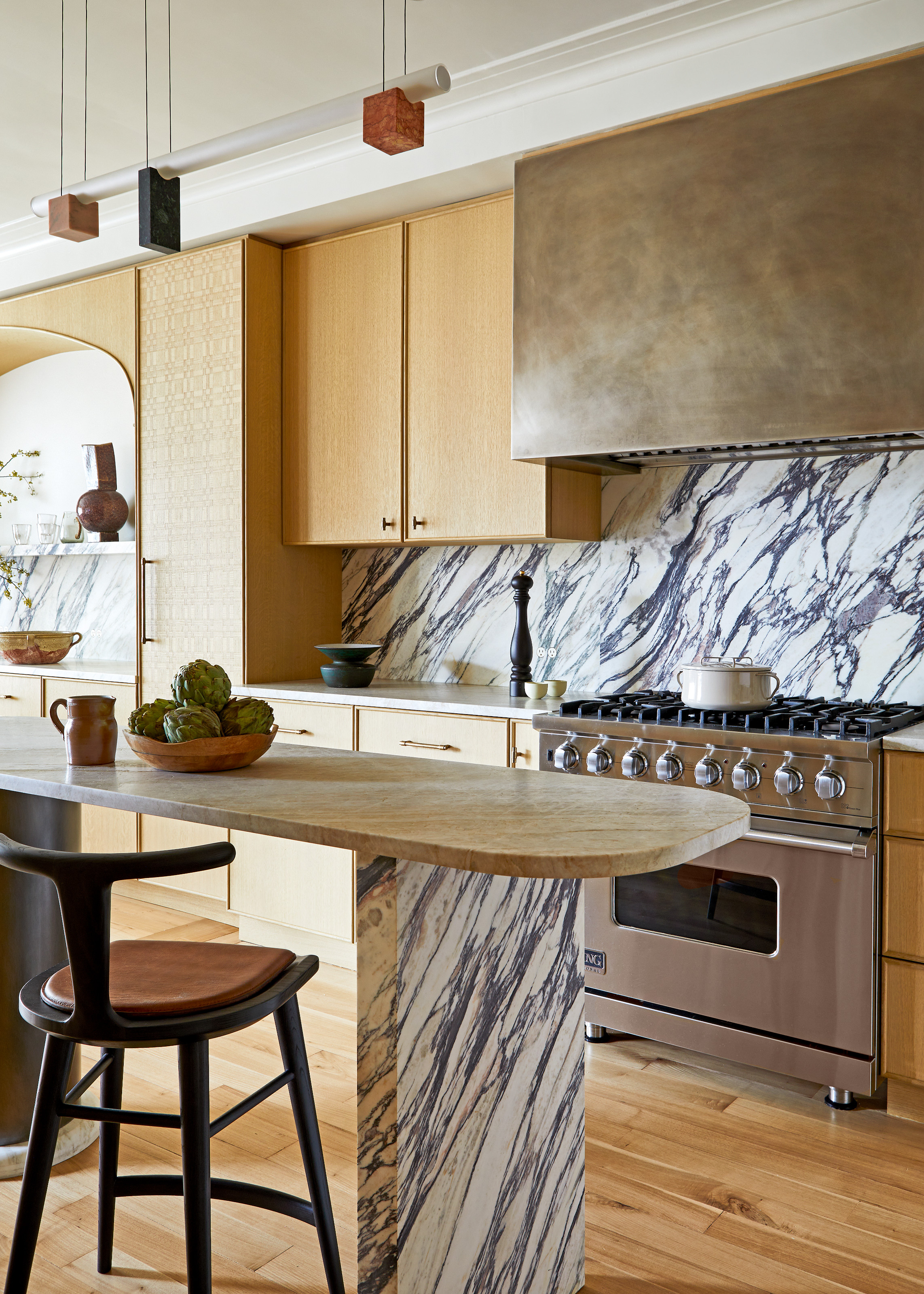 Wood-fronted cabinet kitchen with grey and white marble splashback and island legs