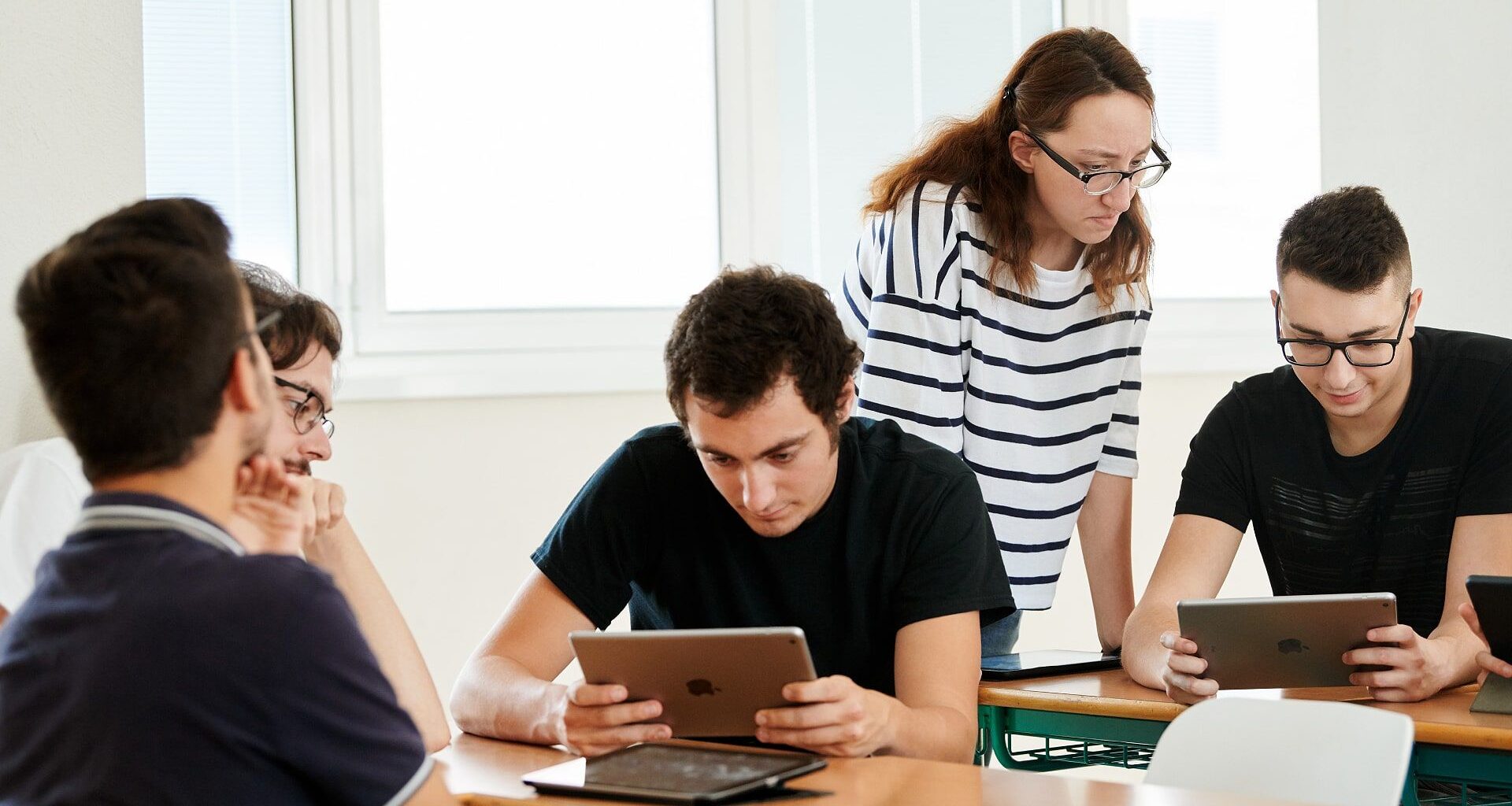 Students using Apple devices in a classroom.