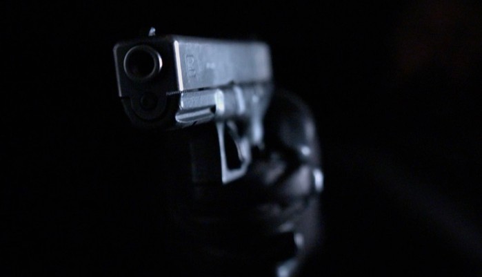 EastEnders flashforwaerd gunman A hand in a black leather glove holds a gun from the shadows in EastEnders.