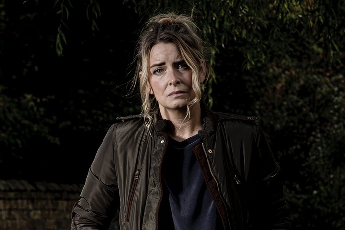 Charity Dingle Charity Dingle stands alone in a field in key art for Emmerdale