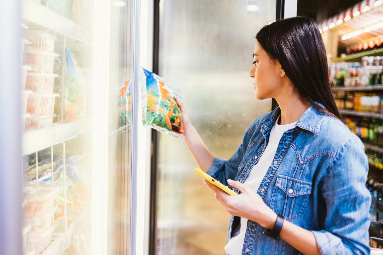 Stock photo: Young brunette woman buying fresh frozen food in the store.
