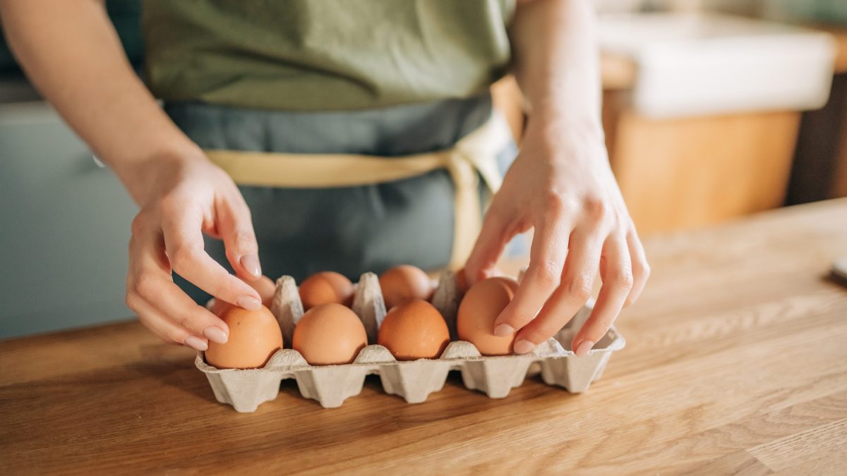 Raw chicken eggs in woman's hands. - stock photo