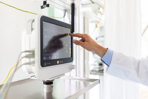 Close-up of a doctor hand checking the vital stats monitor