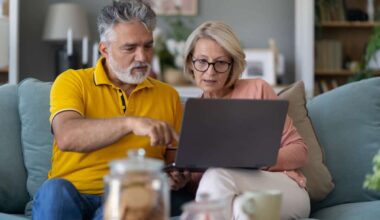 middle-aged couple work together on laptop
