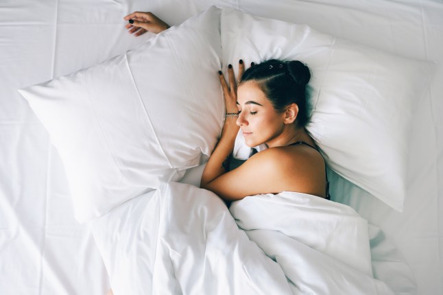 Sleep tourism in hotel. Exhausted woman sleeps sweetly in bed in the morning