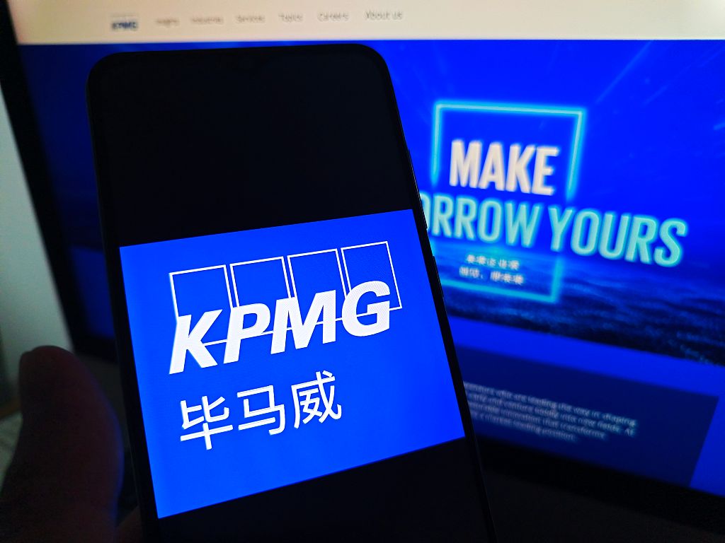 SUQIAN, CHINA - MAY 19, 2026 - A netizen is checking KPMG logo on his mobile phone and KPMG webpage on his computer in Suqian City, Jiangsu Province, China on May 19, 2026. (Photo credit should read CFOTO/Future Publishing via Getty Images)