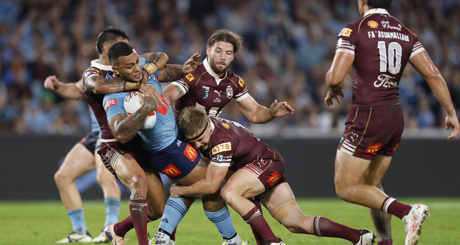 The Blues’ Addin Fonua-Blake is tackled by Maroons players during the first State of Origin game of 2026.