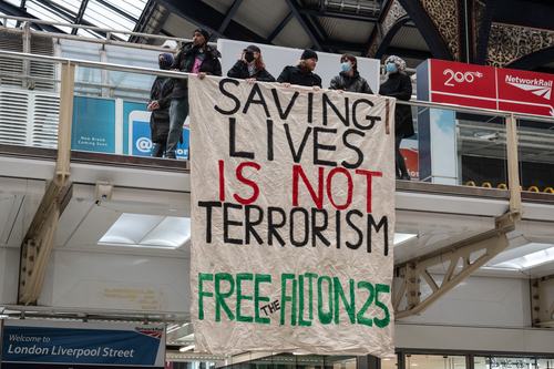 Activists hang giant banners, distribute leaflets and protest in support of the four activists due to be sentenced the following day at Liverpool Street station on June 11, 2026 in London, England. Four of "the Filton 25"