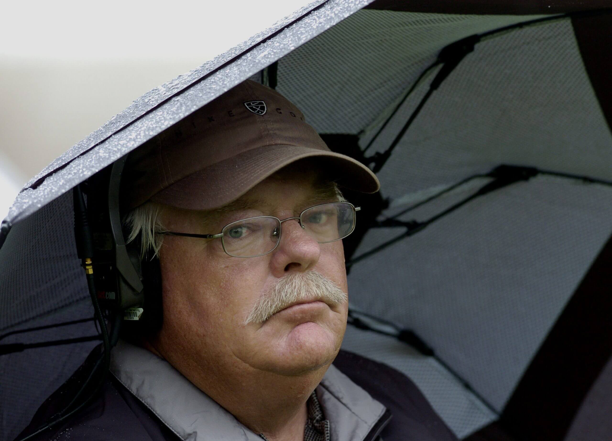 Roger Maltbie hides under an umbrella during a rain storm at the 2005 Arnold Palmer Invitational.