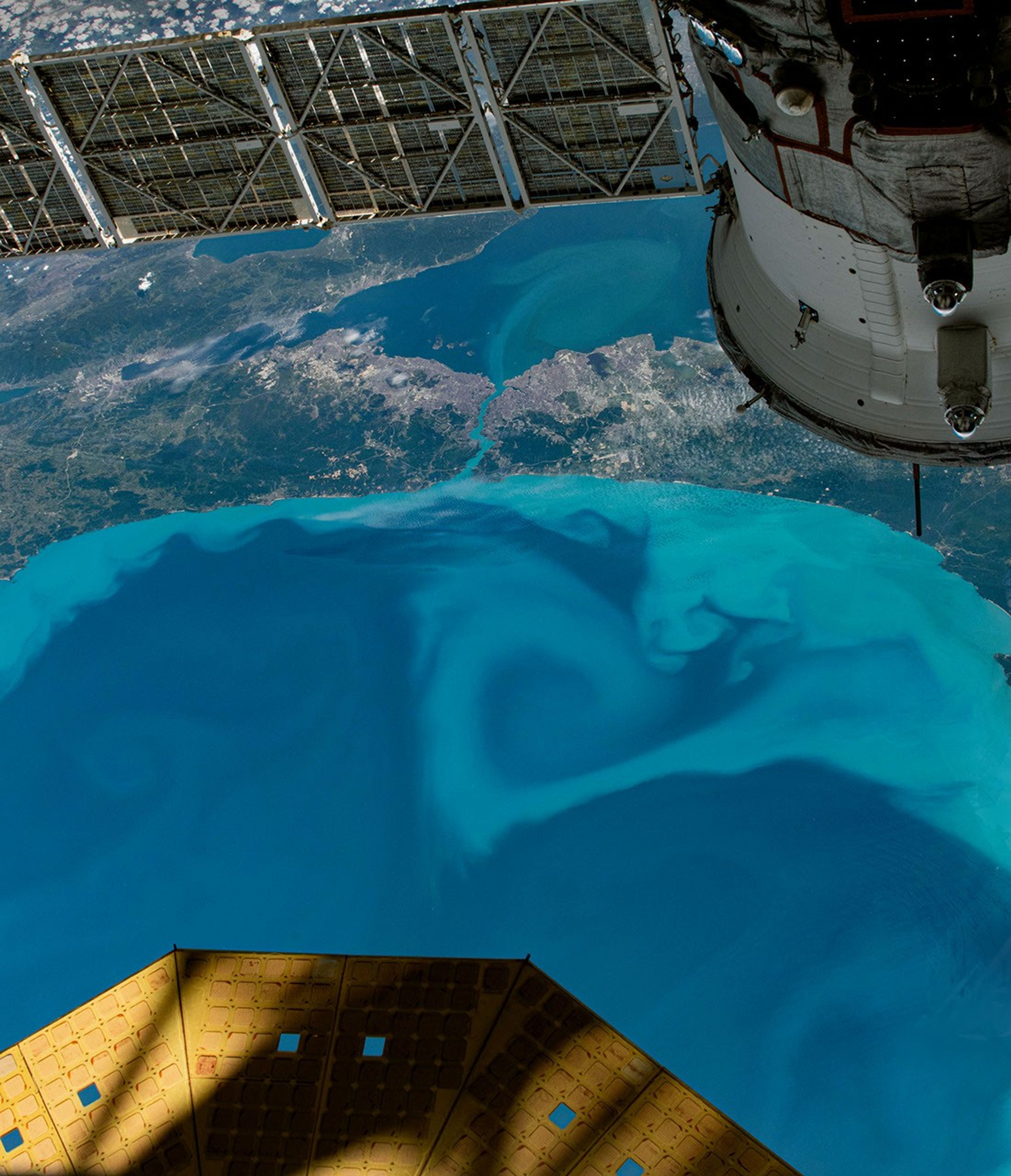 A downward looking photograph shows a detailed view of the southwestern side of the Black Sea, where turquoise swirls extend from the coast and across a narrow strait leading to the Sea of Marmara.