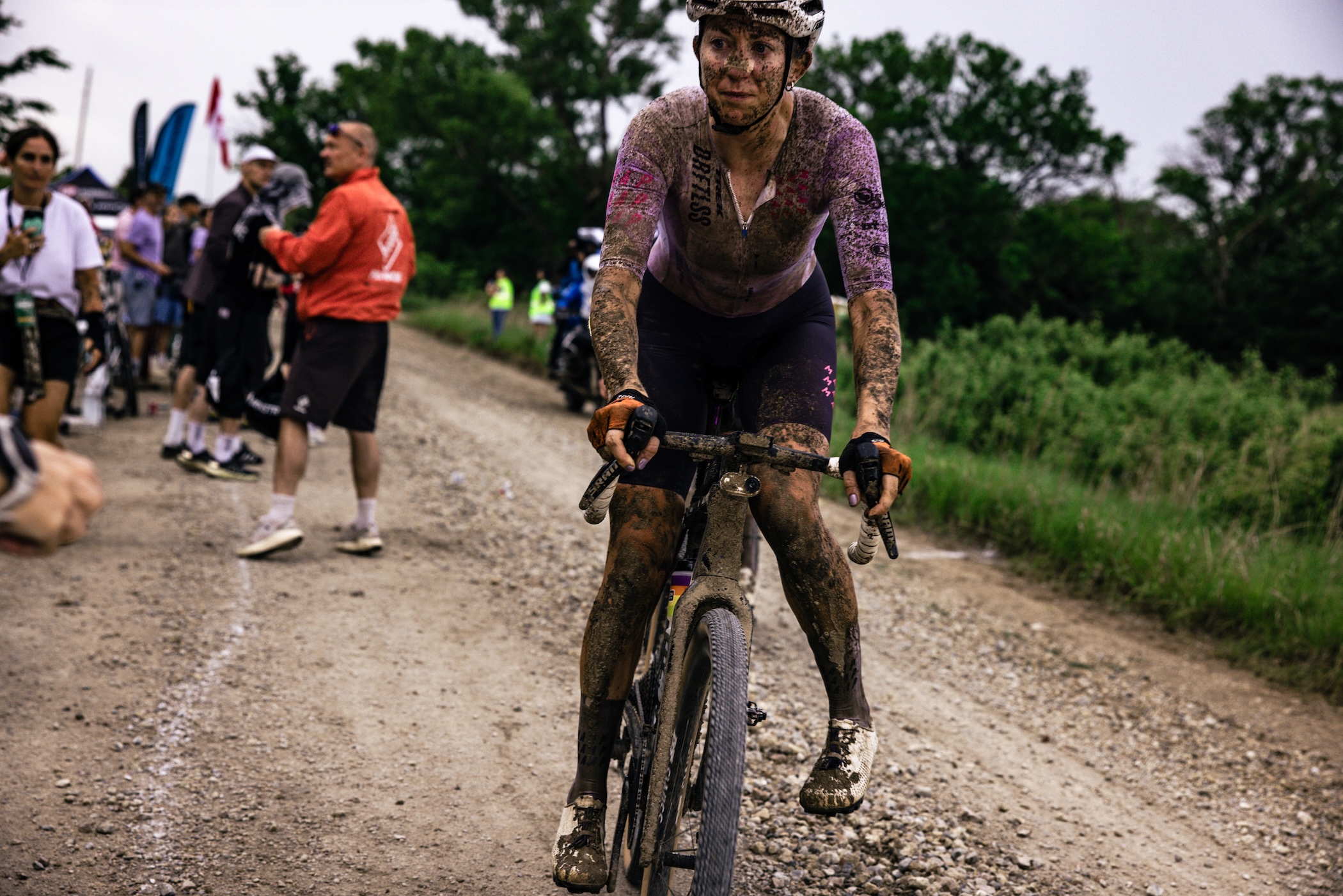 Paige Onweller slows to get crew support at a Feed Zone at 2026 Unbound Gravel 200