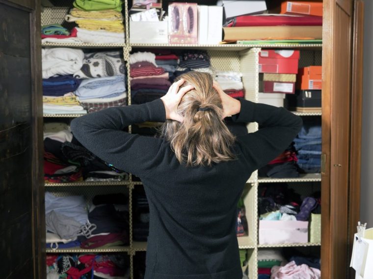 Decluttering the closet, hands on waist