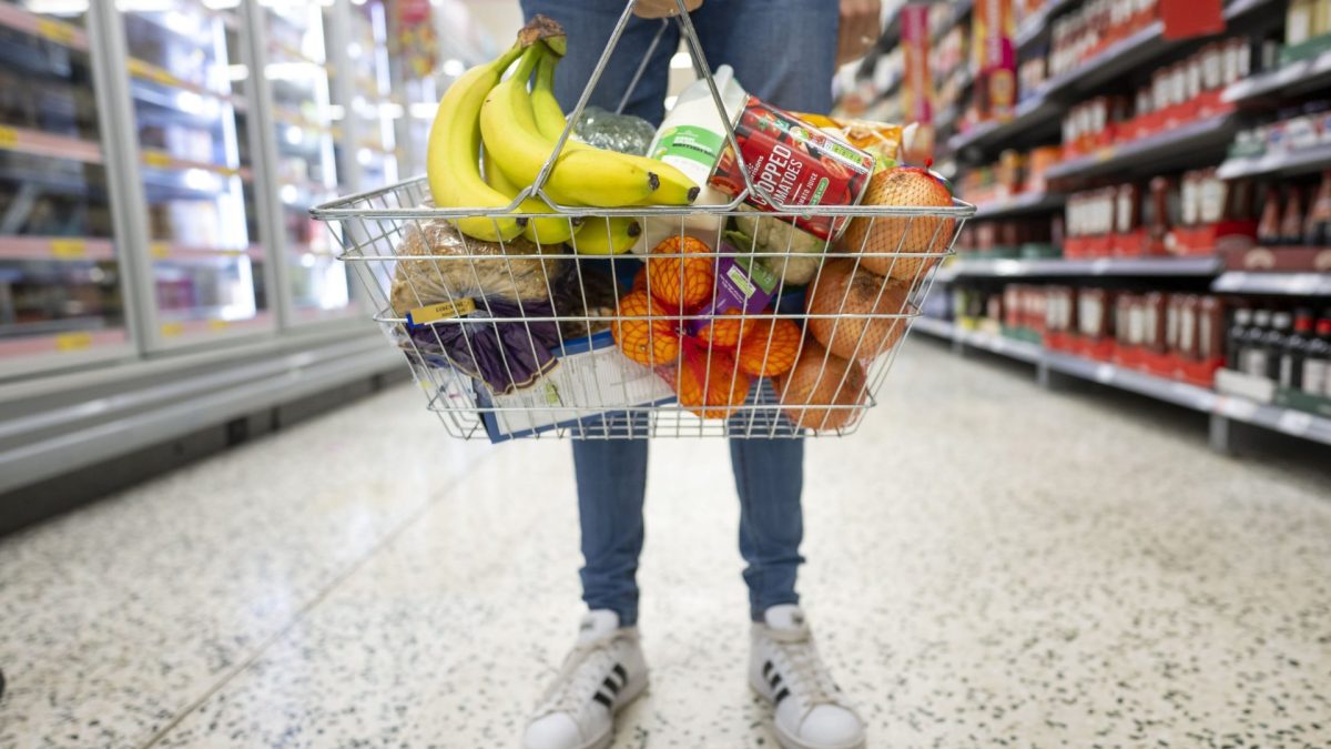 CARDIFF, WALES - MAY 22: A woman holds a shopping basket of groceries on May 22, 2022 in Cardiff, Wales. Last week, the UK Office for National Statistics reported an 6% average increase of food and drink prices year on year, but some staples, such as milk and pasta, had risen by more than 10%. (Photo by Matthew Horwood/Getty Images)