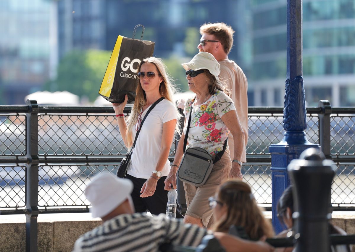 A woman uses a shopping bag to provide shade during the hot weather, near the Tower of London. Parts of England will swelter through temperatures of up to 30C on Friday. Picture date: Friday August 15, 2025. PA Photo. Photo credit should read: Yui Mok/PA Wire