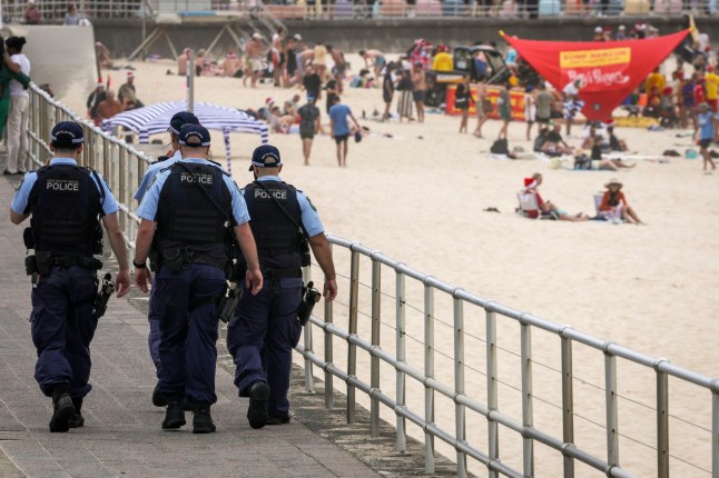 Police officers patrol near beachgoers on Christmas Day at Bondi Beach in Sydney on December 25, 2025. (Photo by DAVID GRAY / AFP via Getty Images) 15416865