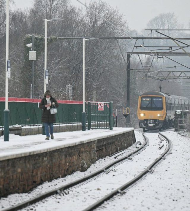 A train arrives into the station in the town of Glossop, Derbyshire, northern England on January 6, 2026, after a light snow covered the region overnight. The UK's Met Office issued fresh weather warnings for January 5-6 for snow and ice for Scotland, Northern Ireland and parts of northern England and said cold weather health alerts for all English regions would remain in place until January 9. (Photo by Oli SCARFF / AFP via Getty Images)