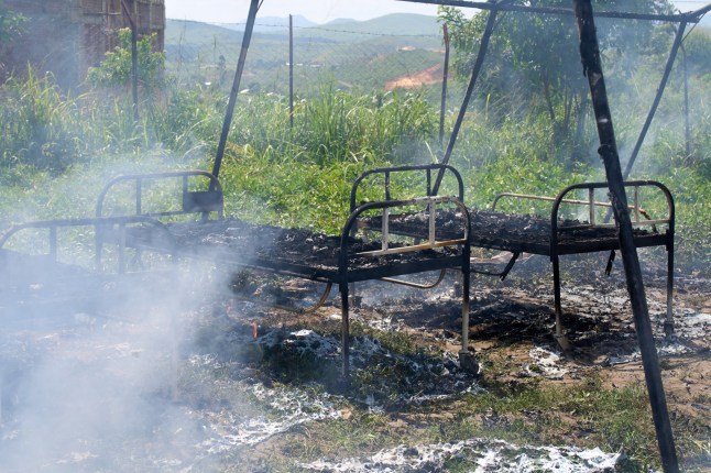 Charred hospital beds stand in smoldering Ebola treatment center in Rwampara, Congo, Thursday, May 21, 2026, after it was set fire by people angry at being stopped from retrieving a body, according to a witness and police. (AP Photo/Dirole Lotsima Dieudonne)