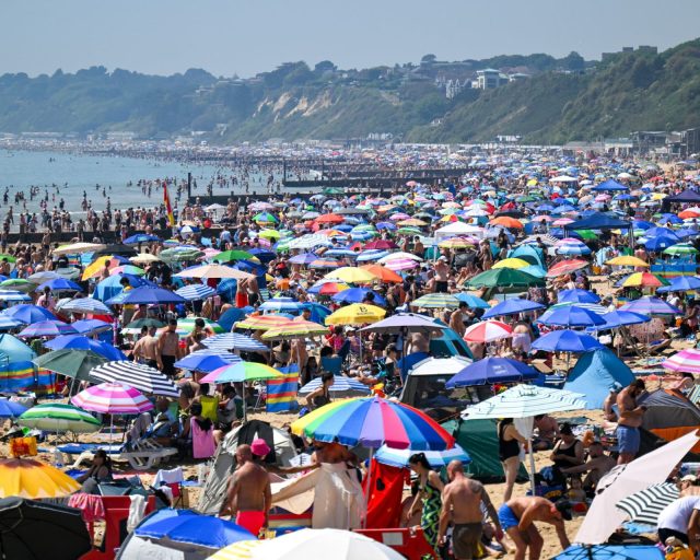 BOURNEMOUTH, ENGLAND - MAY 25: Visitors enjoy the hot weather at Bournemouth beach, on May 25, 2026 in Bournemouth, England. An exceptional bank holiday heatwave is currently bringing record-breaking weather to England with temperatures forecast to climb into the low 30s by Monday. The intense high pressure has prompted the UK Health Security Agency (UKHSA) to issue rare, amber heat alerts across multiple regions due to the health risks for vulnerable people and extreme UV levels. (Photo by Finnbarr Webster/Getty Images)