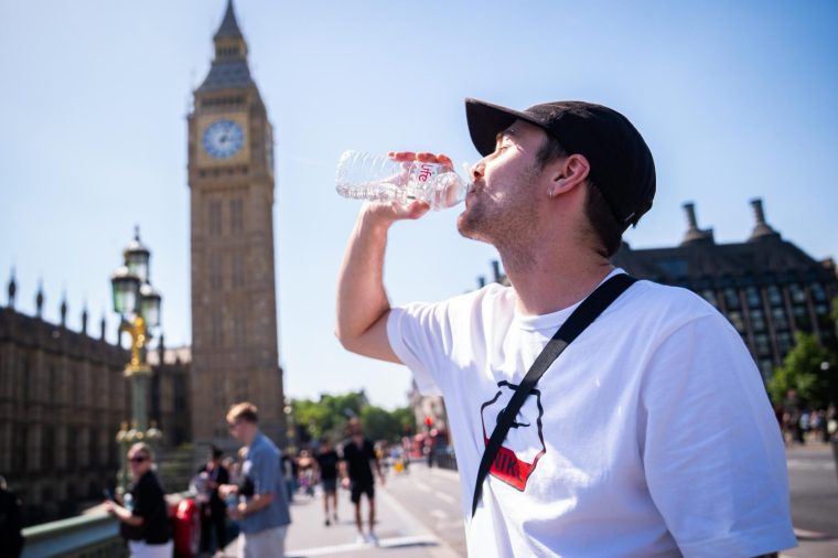 A man cools down with a bottle of water during the hot weather in Westminster Bridge, central London. The UK has recorded its all-time hottest May temperature as a part of London hit 33.5C on Bank Holiday Monday. Picture date: Monday May 25, 2026. PA Photo. The Met Office has said heatwave conditions were met in eight parts of England on Sunday - Heathrow in Greater London, Benson in Oxfordshire, Brooms Barn in Suffolk, High Beech in Essex, Kew Gardens in London, Northolt in London, Santon Downham in Suffolk and Writtle in Essex. Photo credit should read: James Manning/PA Wire