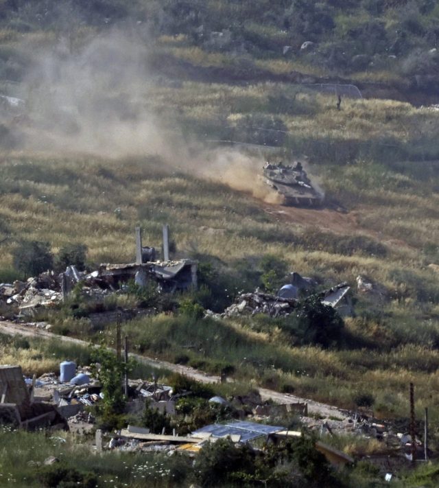 TOPSHOT - This picture taken from a position in the Upper Galilee region in northern Israel shows an Israeli tank taking position amid destroyed buildings in southern Lebanon on May 31, 2026. Israeli Prime Minister Benjamin Netanyahu vowed to push deeper into Lebanon after his military took over the medieval castle of Beaufort on May 31, calling it a 