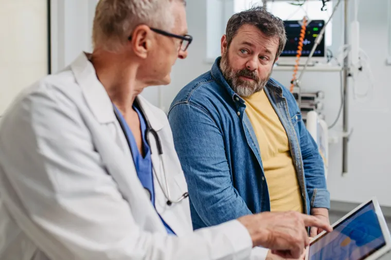 Patient consultation. Doctor explaining medical procedure to man.