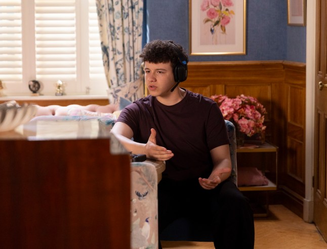FROM ITV STRICT EMBARGO - No Use Before Tuesday 16th June 2026 Coronation Street - Ep 11886.87 Thursday 25th June 2026 Susie activates Will Driscoll???s [LUCAS HODGSON-WALE] games console and selects a player called Minimog16. Suddenly she hears Megan???s voice but when Susie reveals who she is, the player quickly disconnects. When Susie tells Ollie Driscoll [RAPHAEL AKUWUDIKE], he and Maggie Driscoll [PAULINE MCLYNN] burst into the back room to find Will chatting on his headset. Picture contact - David.crook@itv.com Photographer - Danielle Baguley This photograph is (C) ITV and can only be reproduced for editorial purposes directly in connection with the programme or event mentioned above, or ITV plc. This photograph must not be manipulated [excluding basic cropping] in a manner which alters the visual appearance of the person photographed deemed detrimental or inappropriate by ITV plc Picture Desk. This photograph must not be syndicated to any other company, publication or website, or permanently archived, without the express written permission of ITV Picture Desk. Full Terms and conditions are available on the website www.itv.com/presscentre/itvpictures/terms