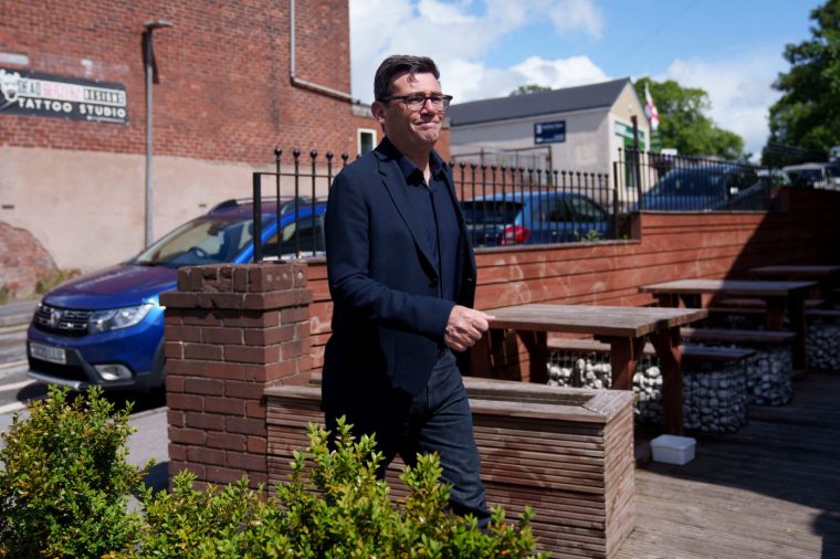 Andy Burnham walks during a campaign visit to the town of Ashton-in-Makerfield before the forthcoming Makerfield by-election, in Greater Manchester, England, Tuesday, June 9, 2026. (AP Photo/Jon Super)