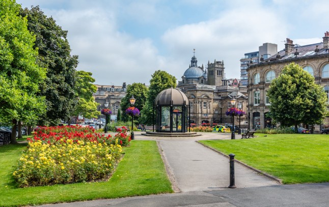 Harrogate, United Kingdom - July 21 2021: The Crescent Gardens in the centre of Harrogate with the dome of the Royal Baths in the background. The building now includes a Turkish Bath and Chines Restaurant. Harrogate, North Yorkshire, United Kingdom