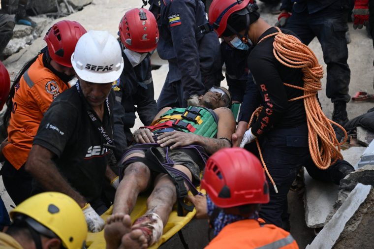EDITORS NOTE: Graphic content / Venezuelan Civil Protection members and firefighters rescue 21-year-old Patrick Vargas from the rubble of a collapsed building in Catia La Mar, La Guaira, Venezuela, on June 26, 2026, following earthquakes. The death toll from two powerful earthquakes that devastated Venezuela earlier this week rose to 920 on June 26, National Assembly President Jorge Rodriguez said. (Photo by Federico PARRA / AFP via Getty Images)