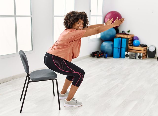 Young african american woman smiling confident stretching at sport center
