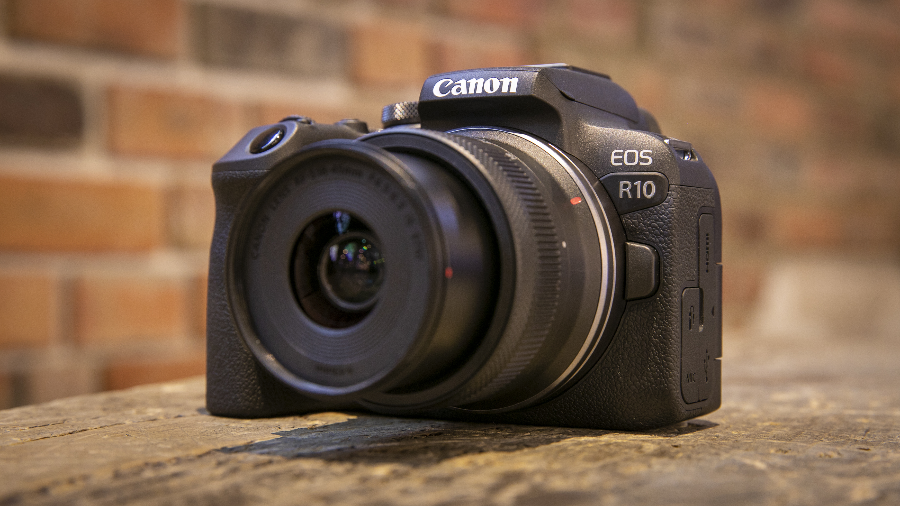 Canon EOS R10 mirrorless camera placed on a wooden surface