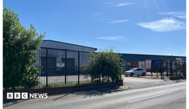 Station Road in Rowley Regis has buildings on either side and vehicles can be seen driving down it