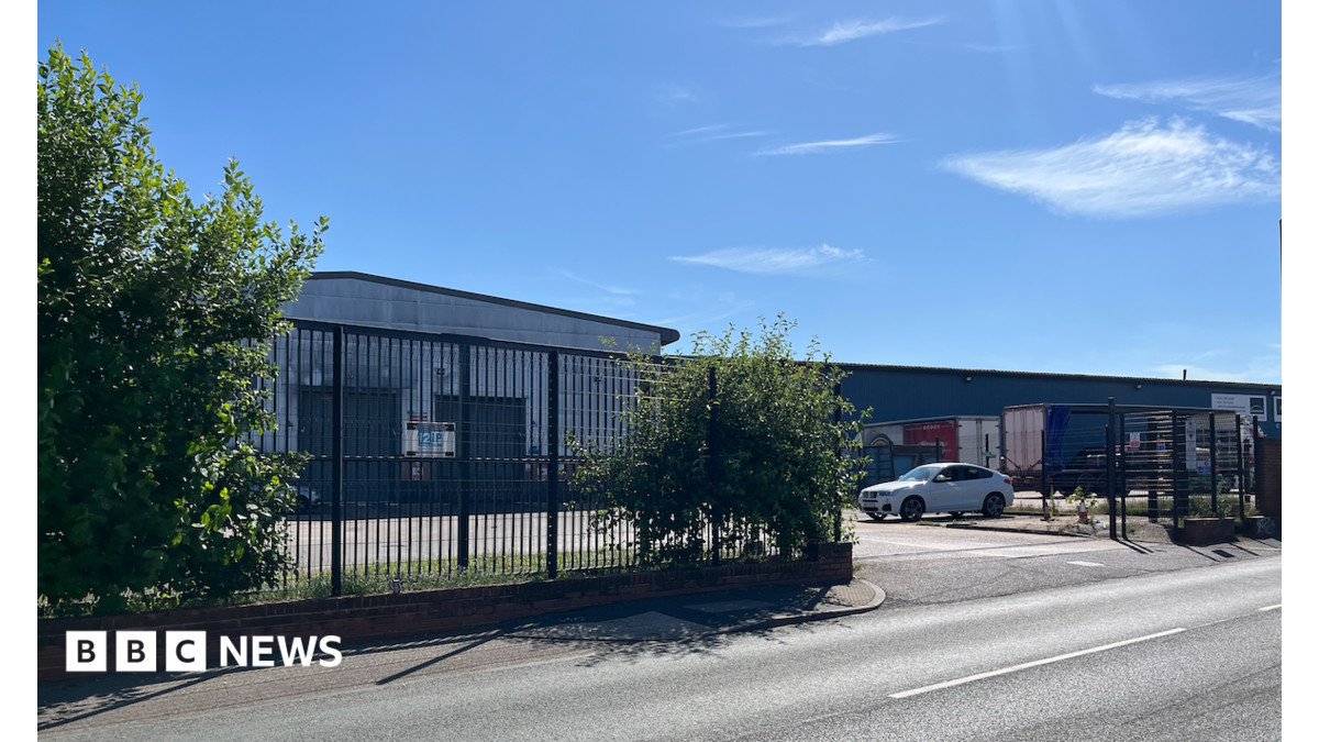 Station Road in Rowley Regis has buildings on either side and vehicles can be seen driving down it