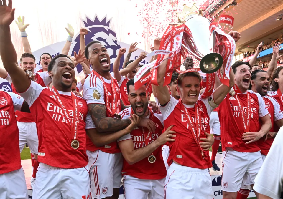 Arsenal captain Martin Odegaard lifts the Premier League trophy as (L) Jurrien Timber, (2ndL) Gabriel Magalhaes, (3rdL) Mikel Merino and (R) Declan Rice celebrate after the Premier League match between Crystal Palace and Arsenal