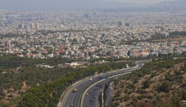 Aerial view of Athens and the Attica basin, showing dense residential areas and roads.