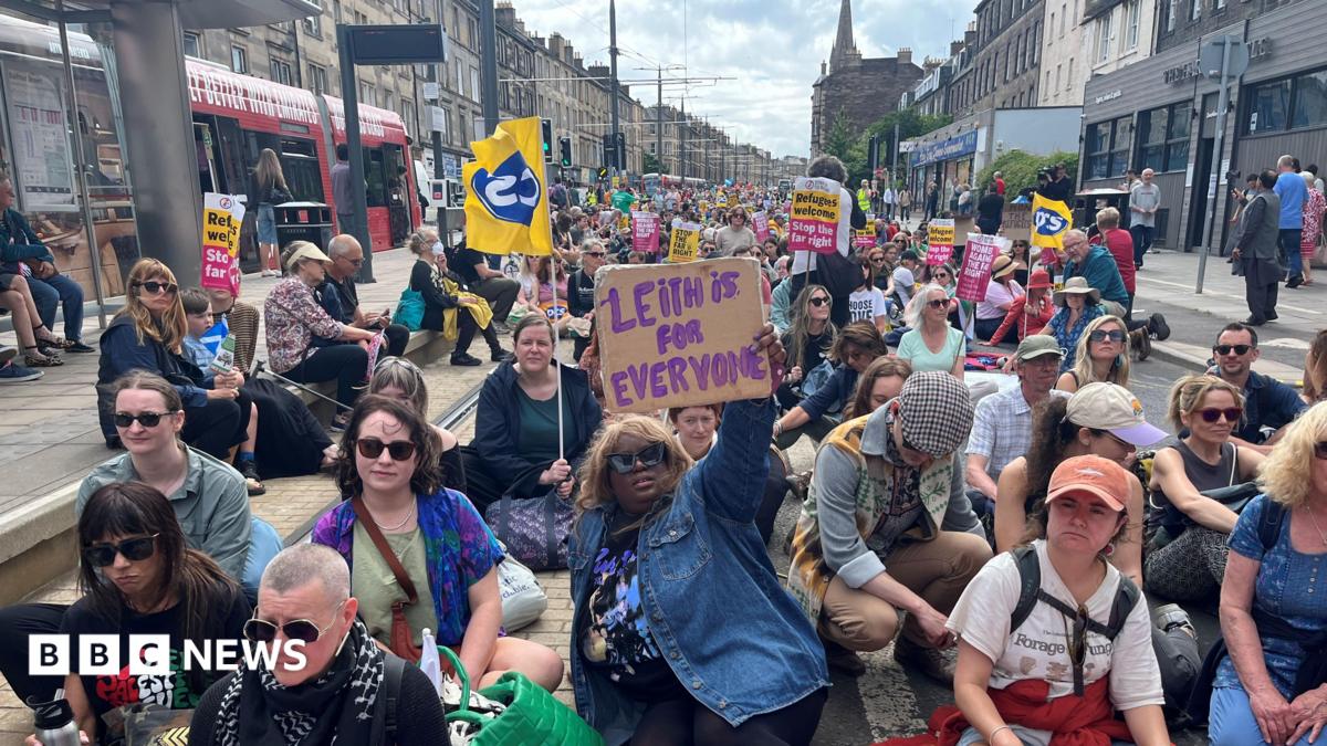 Leith demo - hundreds of protesters are sitting in a road with anti-racism banners