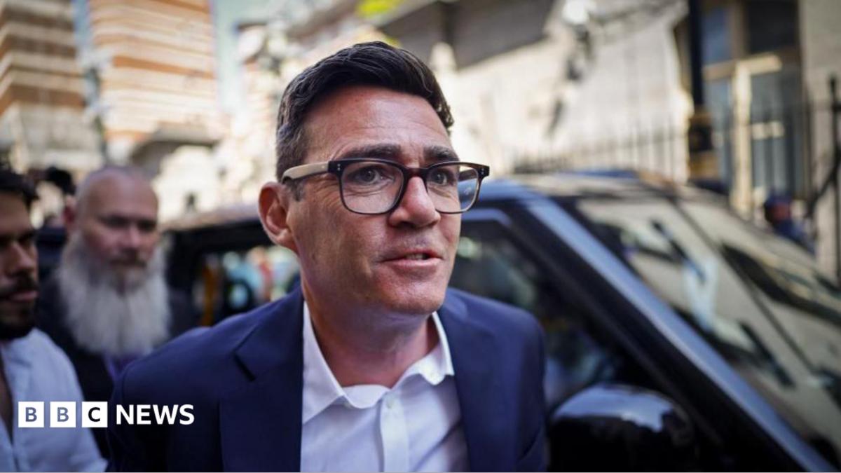 Image shows Andy Burnham wearing black-rimmed glasses and a blue suit, arriving at the Houses of Parliament in Westminster, London, Britain, on 22 June 2026